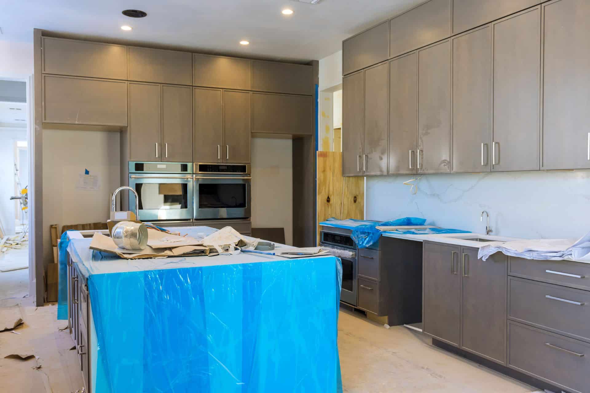 A mid-range kitchen remodel with a $50,000 budget includes semi-custom cabinets, quality countertops, upgraded appliances, hardwood or tile flooring, advanced lighting, designer paint and backsplash, and covers professional labor and additional expenses.