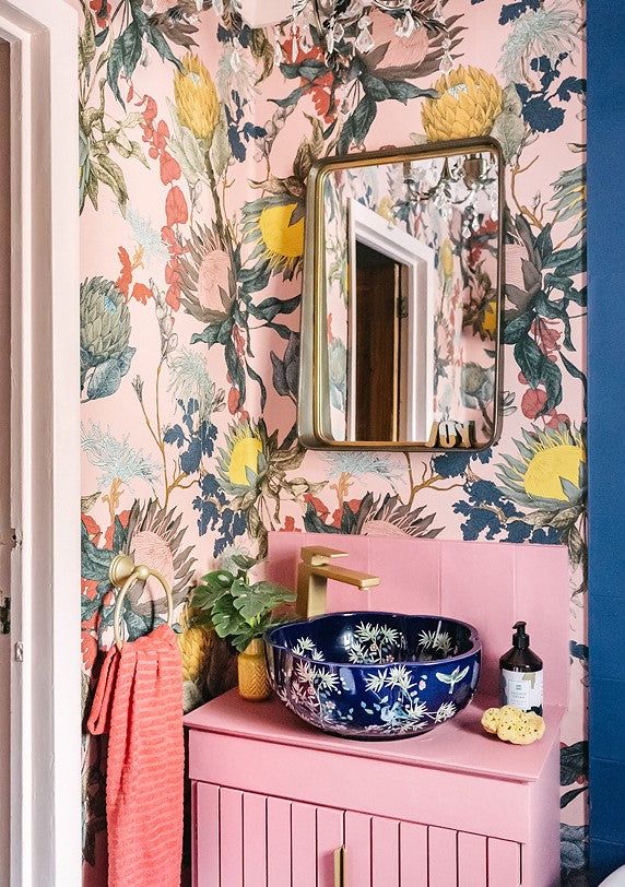 Choose a bold patterned wallpaper to serve as a lively canvas for your bathroom. Accent it with a brightly colored vanity and a decorative sink to create a playful, eclectic mix.