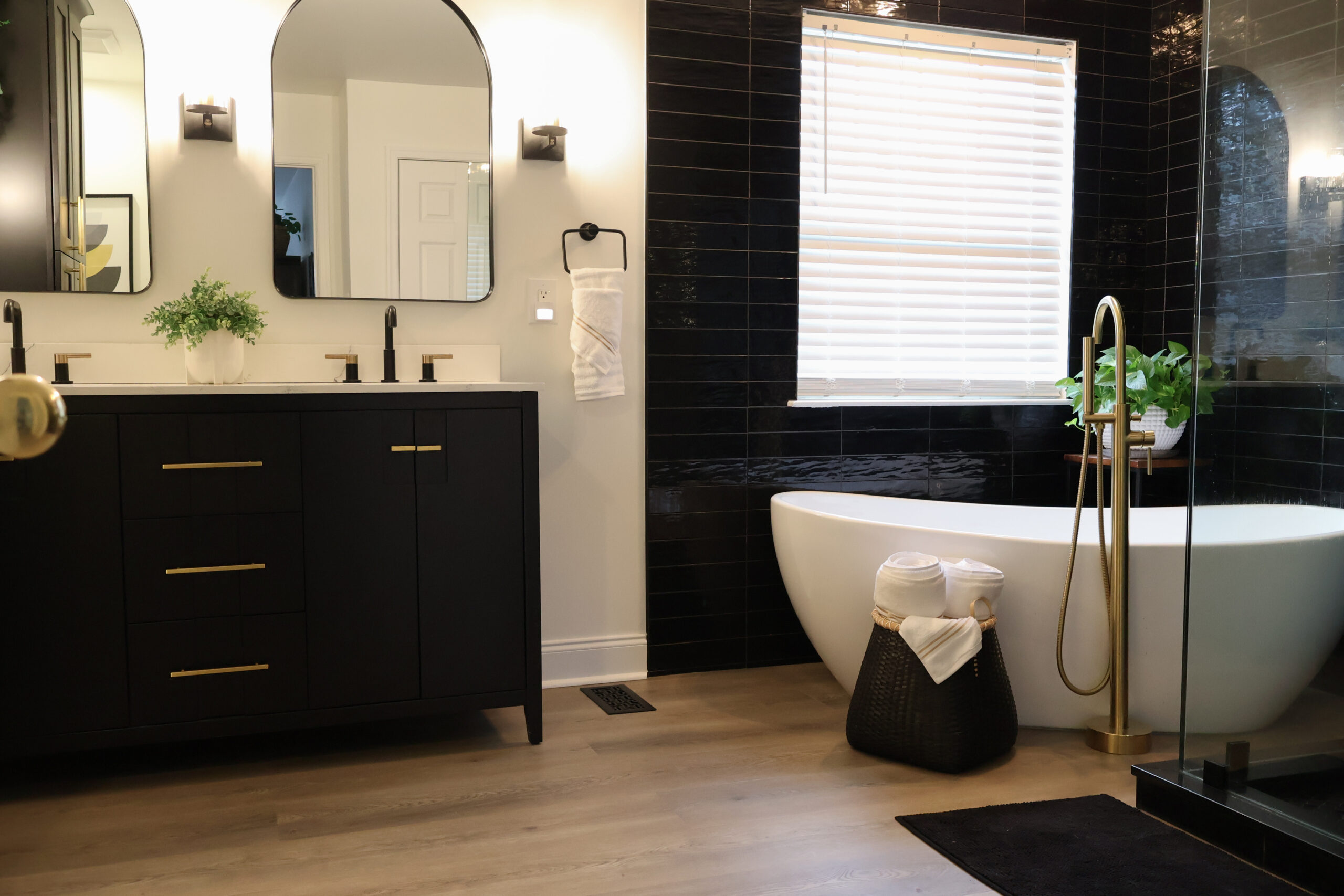 Wide view of a Dupont Circle DC bathroom remodel showing the black double vanity and white freestanding soaking tub.