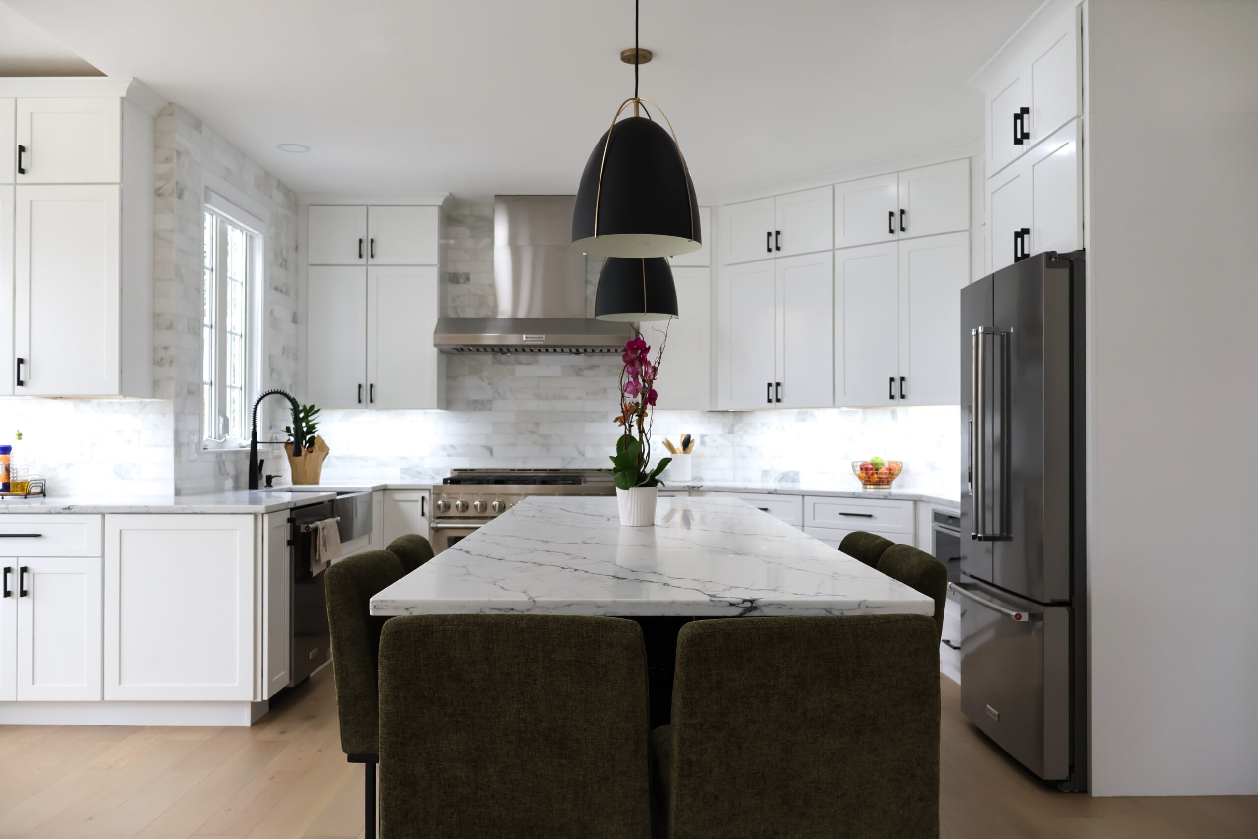 Large black and gold pendant lighting used in a modern kitchen design.