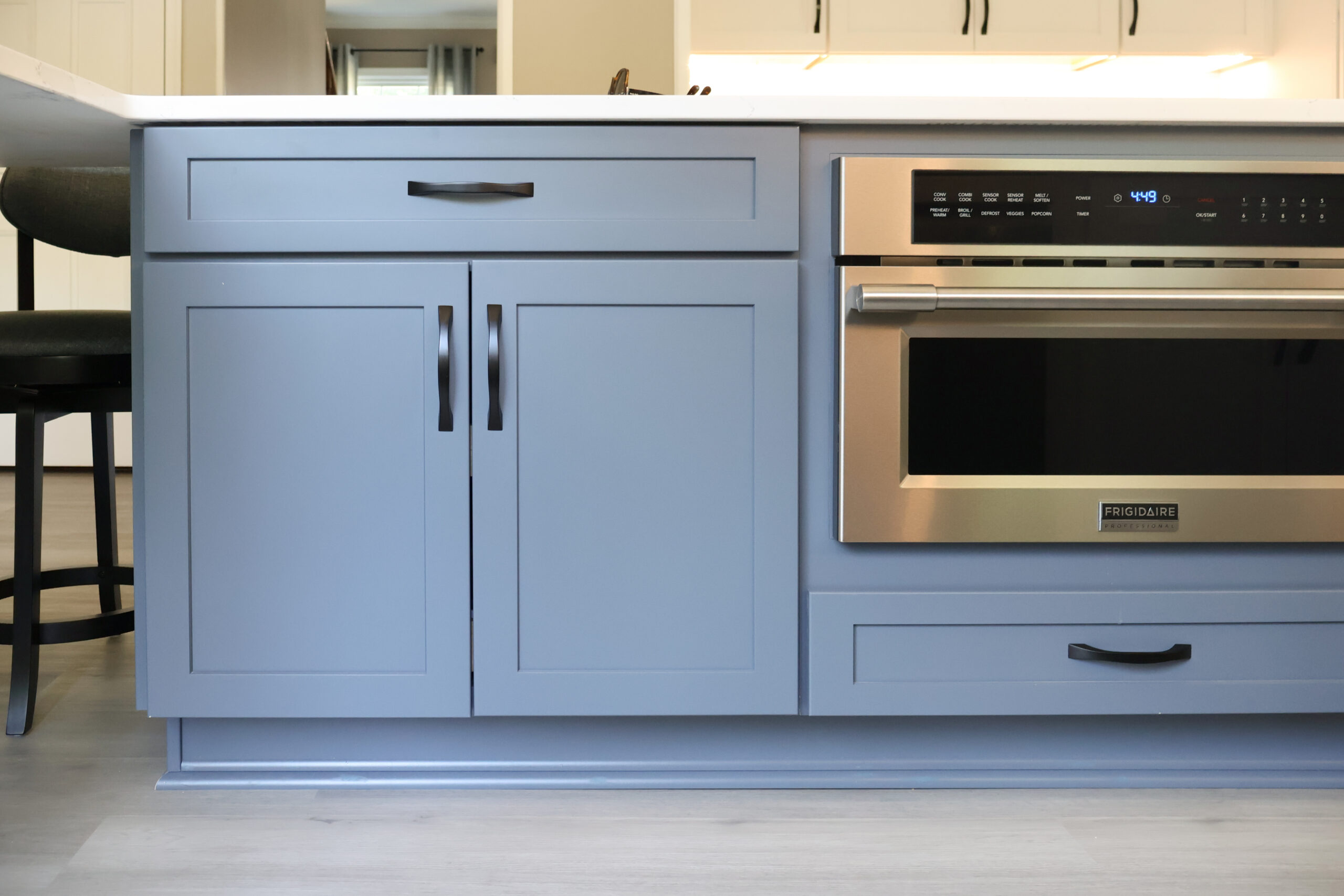 Blue island cabinetry with an integrated stainless microwave drawer.