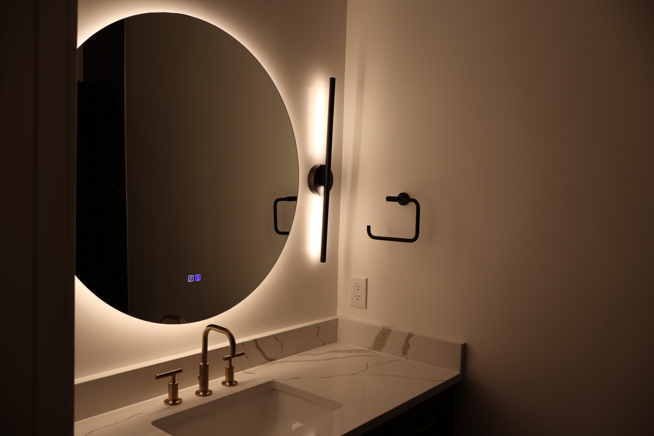 Reflection of vanity and gold fixtures in a lighted LED mirror for a Bathroom update
