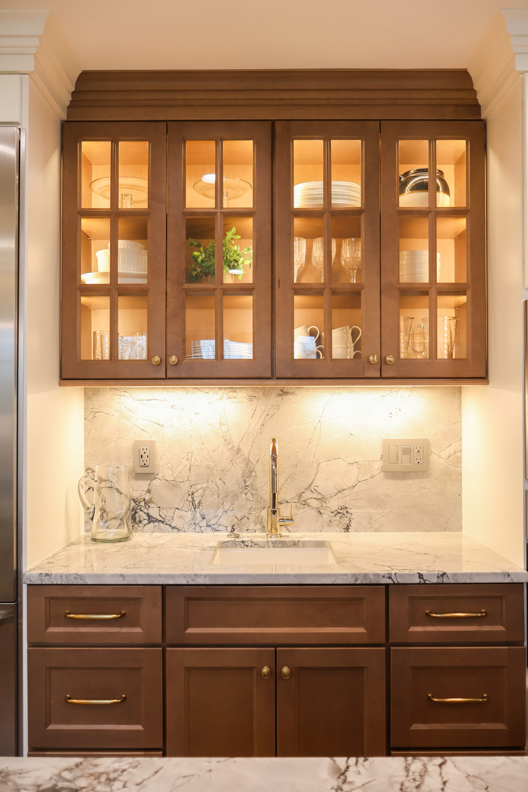 Full view of a custom Georgetown DC home wet bar with stained wood cabinetry, marble slab backsplash, and a small prep sink.