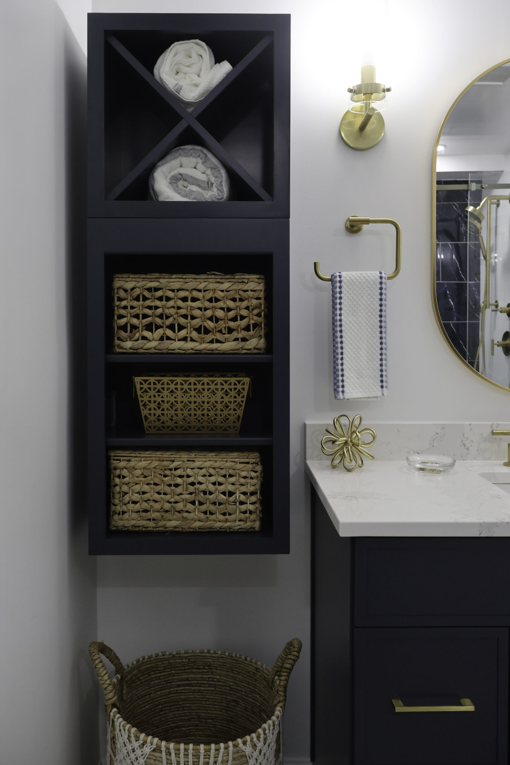 Built in navy blue shelving unit with custom X cross towel storage.