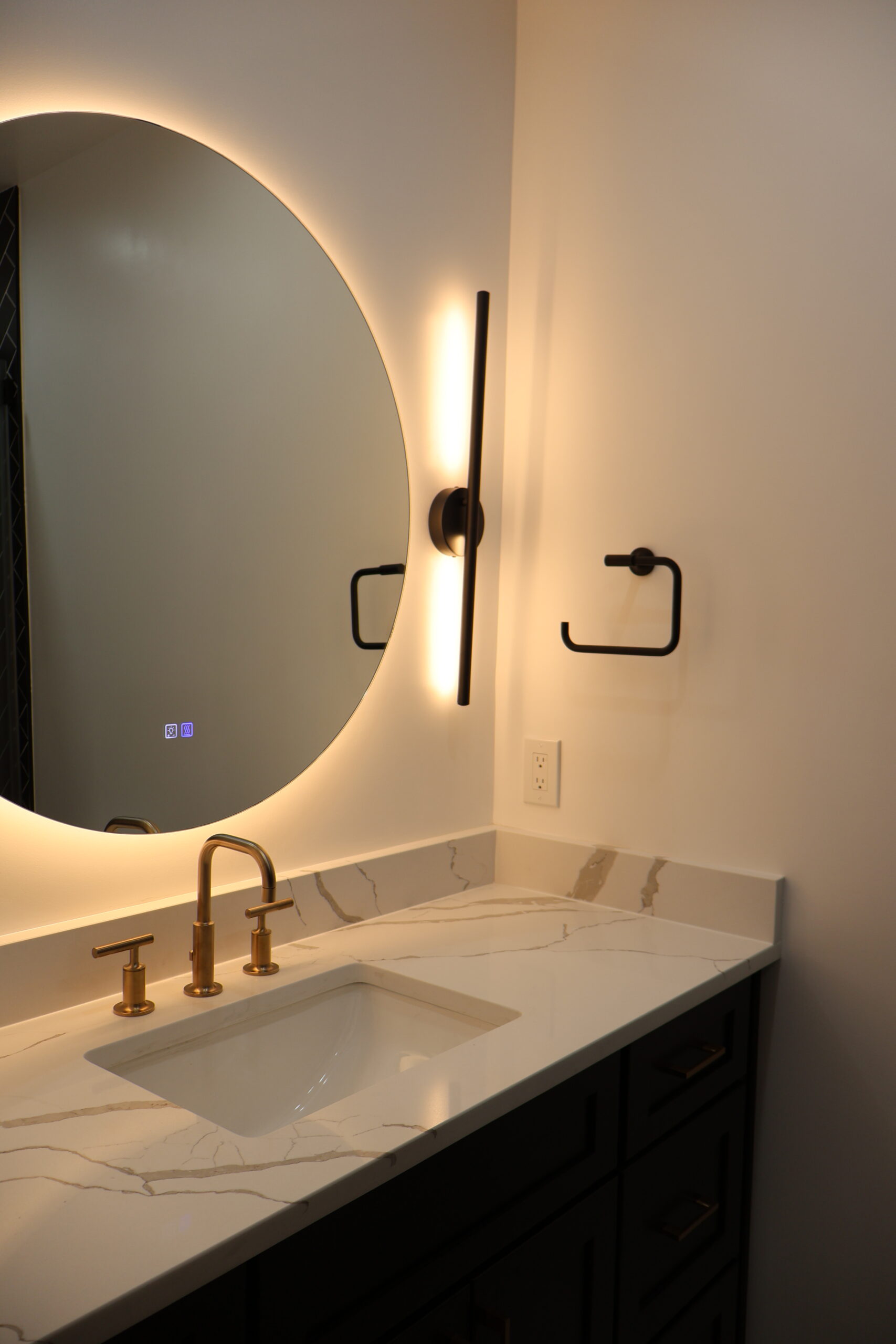 Detail of dark shaker cabinet drawers with brushed gold pulls and quartz counter.