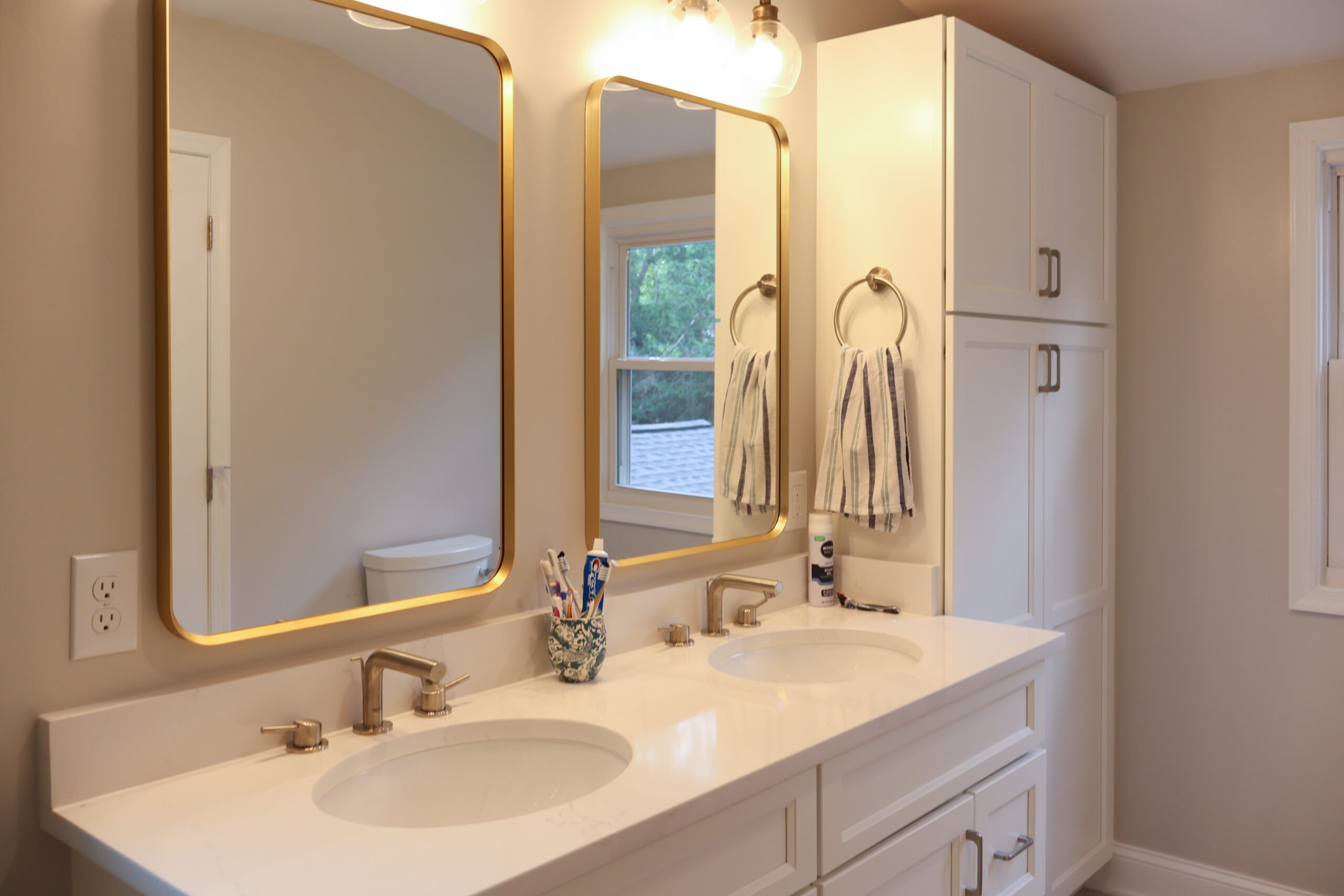 Bathroom remodeling detail of double vanity with quartz top and under-mount sinks.