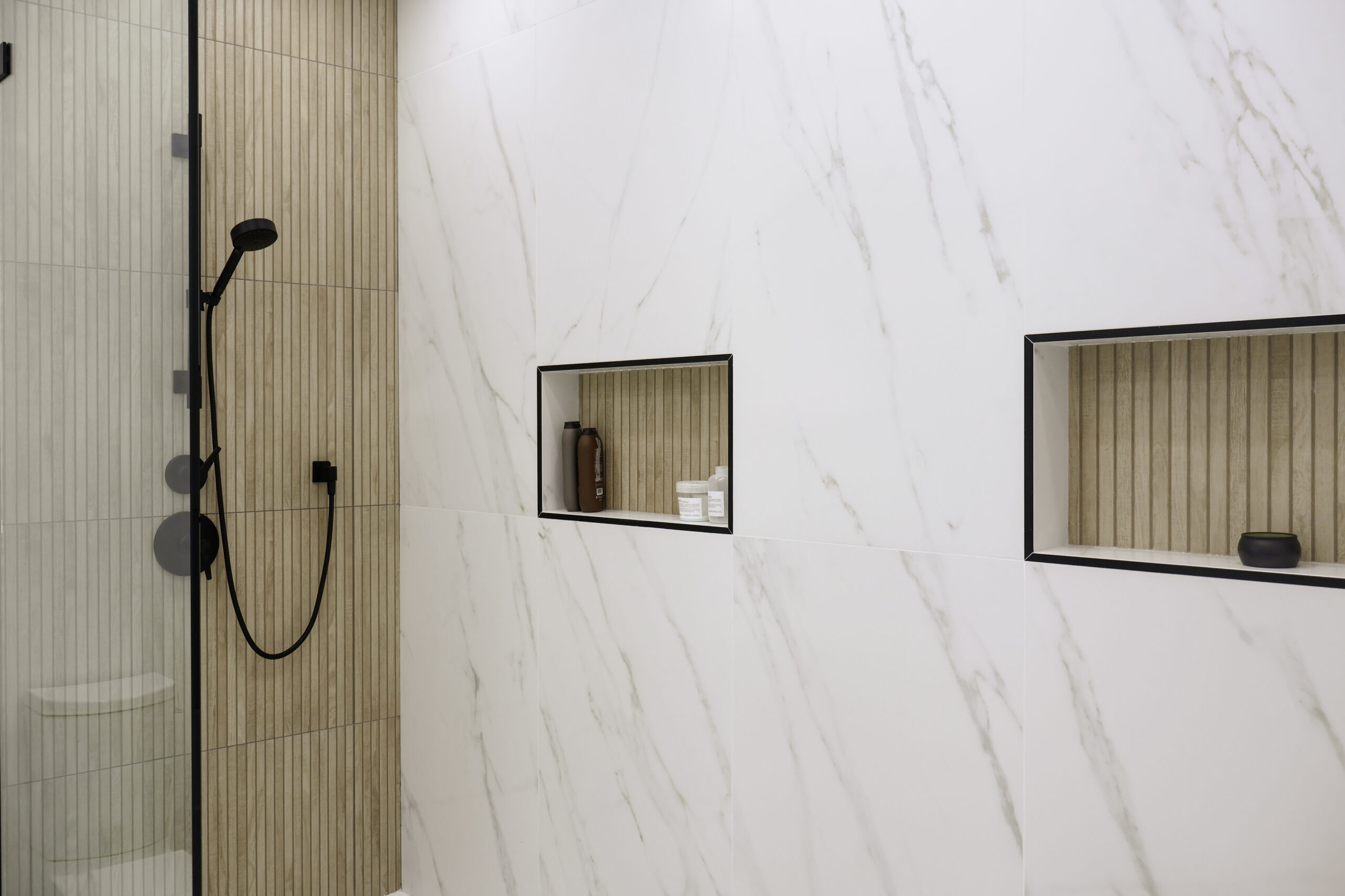 Recessed shower niches with wood slat tile backing for a Bathroom renovation.