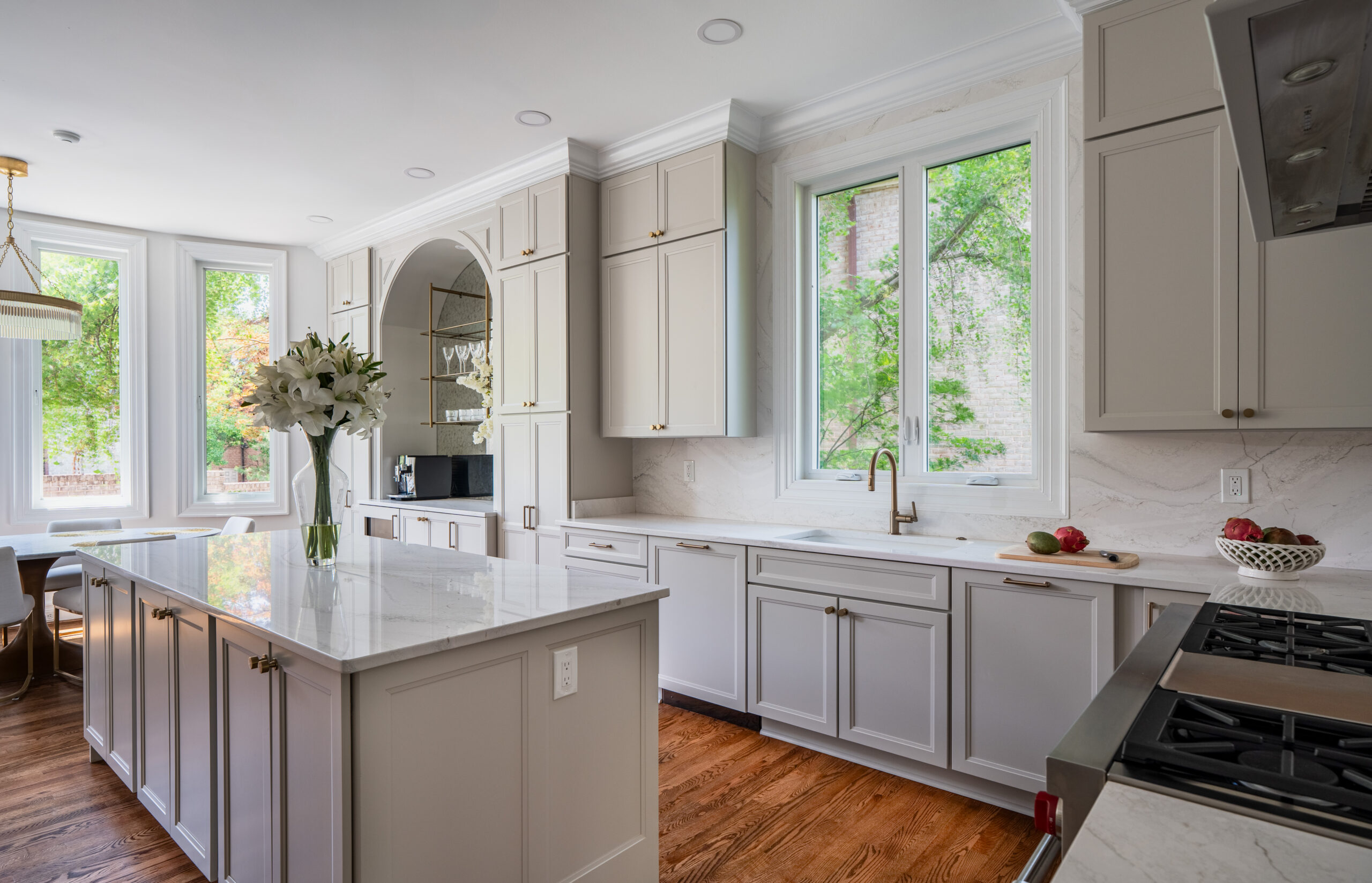 A wide perspective of the kitchen showing the island, high-end appliances, and the transition to the dining area.