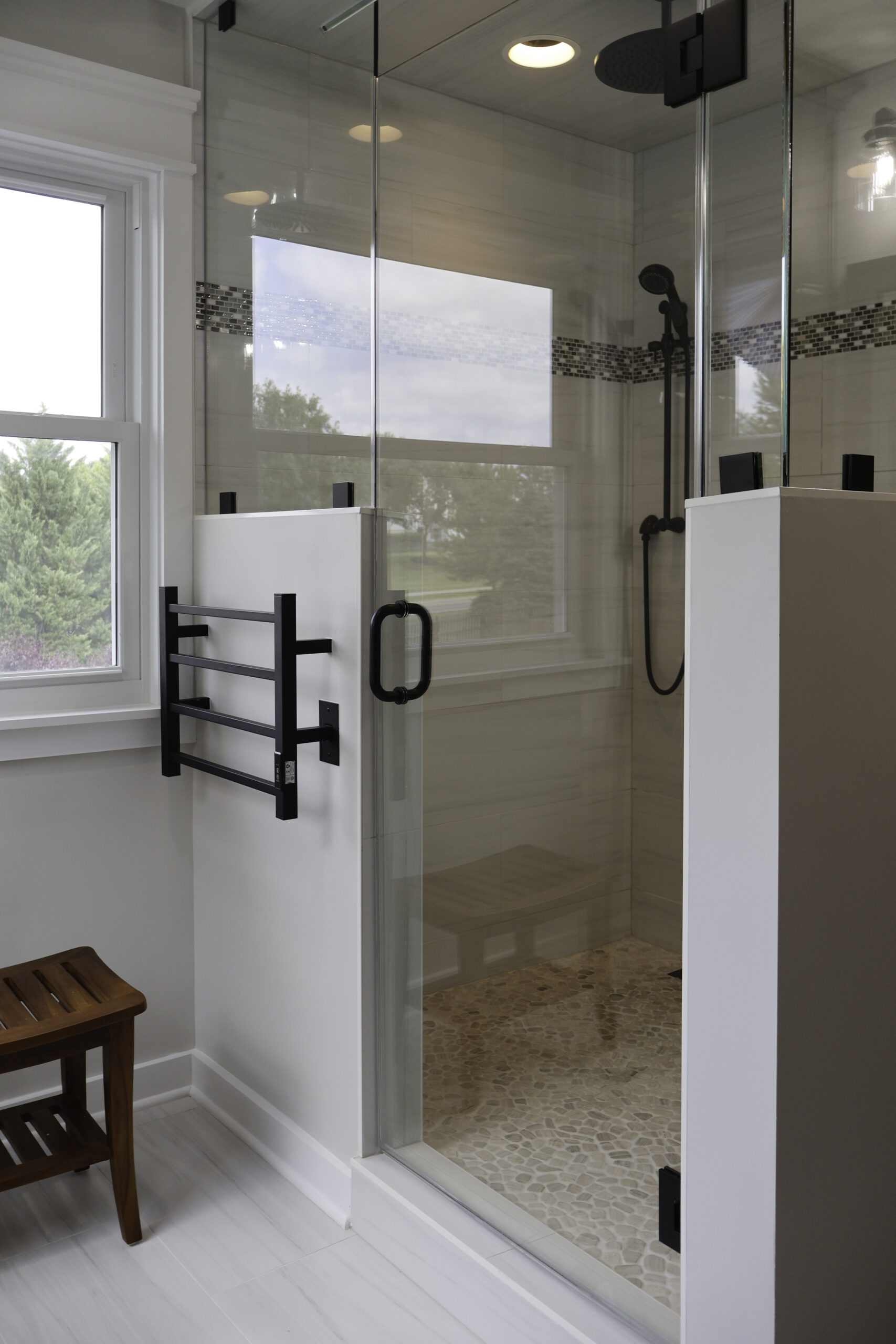 Custom frameless glass shower enclosure with matte black hardware for a Bathroom remodeling