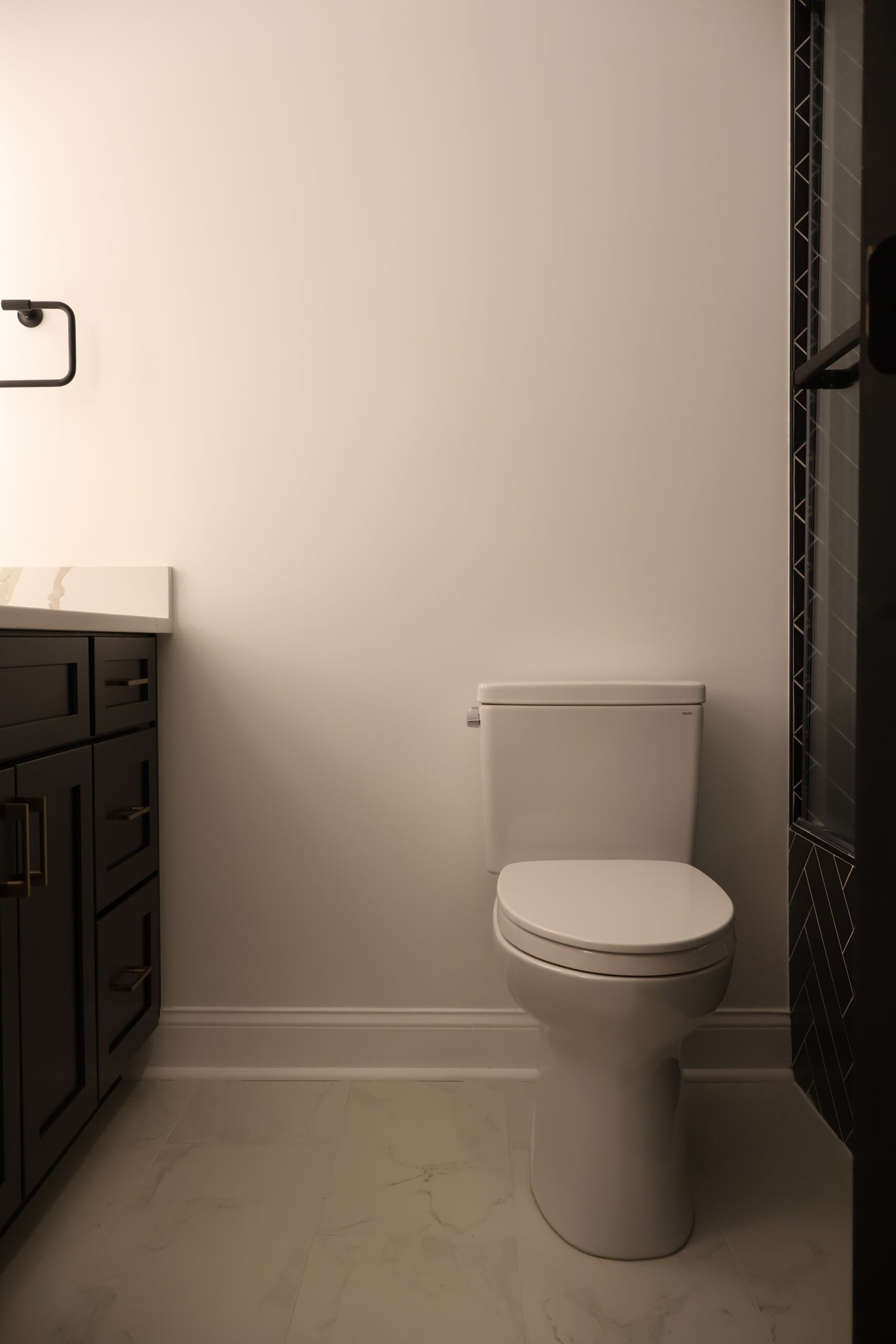 Detailed view of black porcelain tile hand laid in a herringbone pattern.