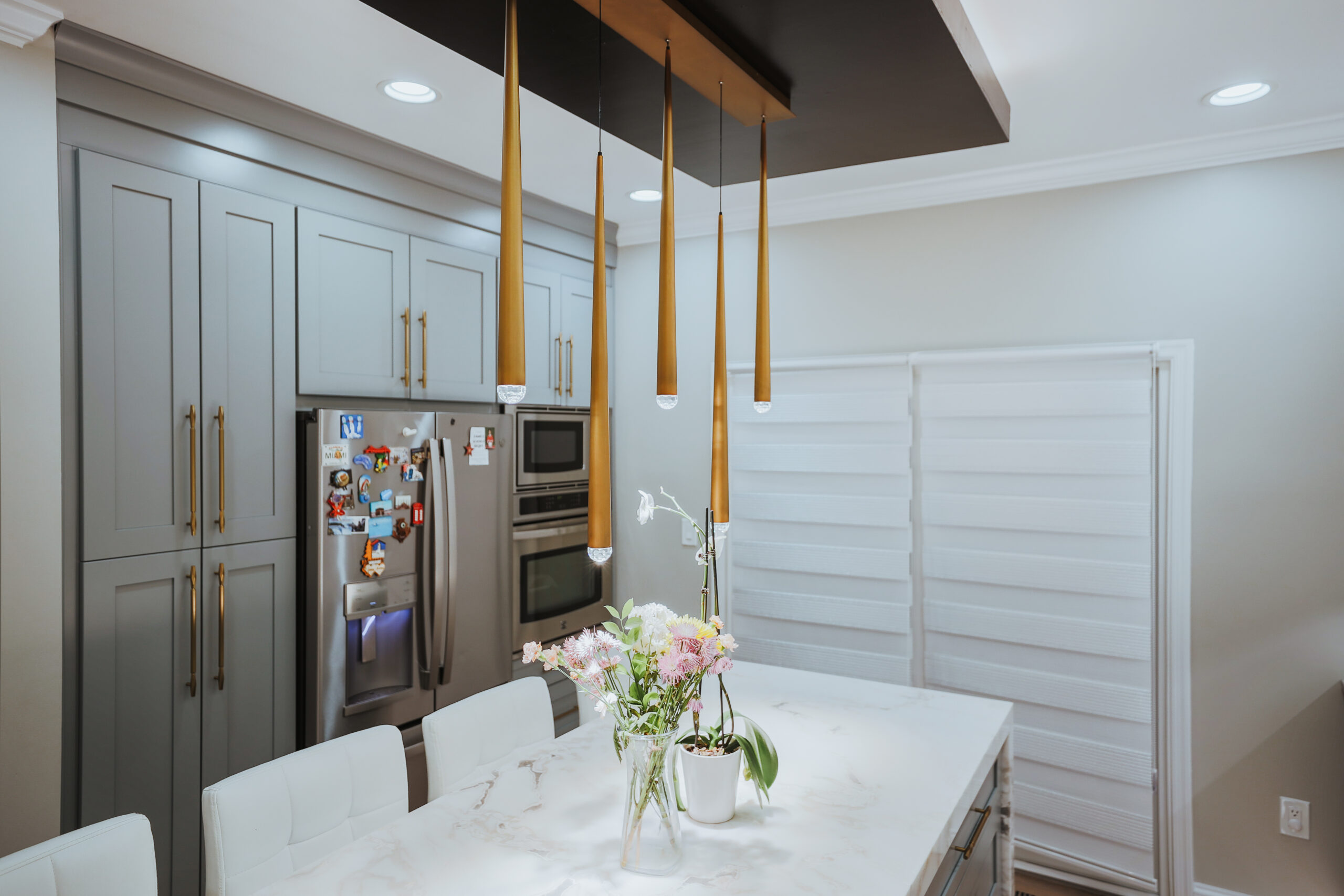 Integrated stainless refrigerator and wall ovens in gray custom cabinetry for a Kitchen update
