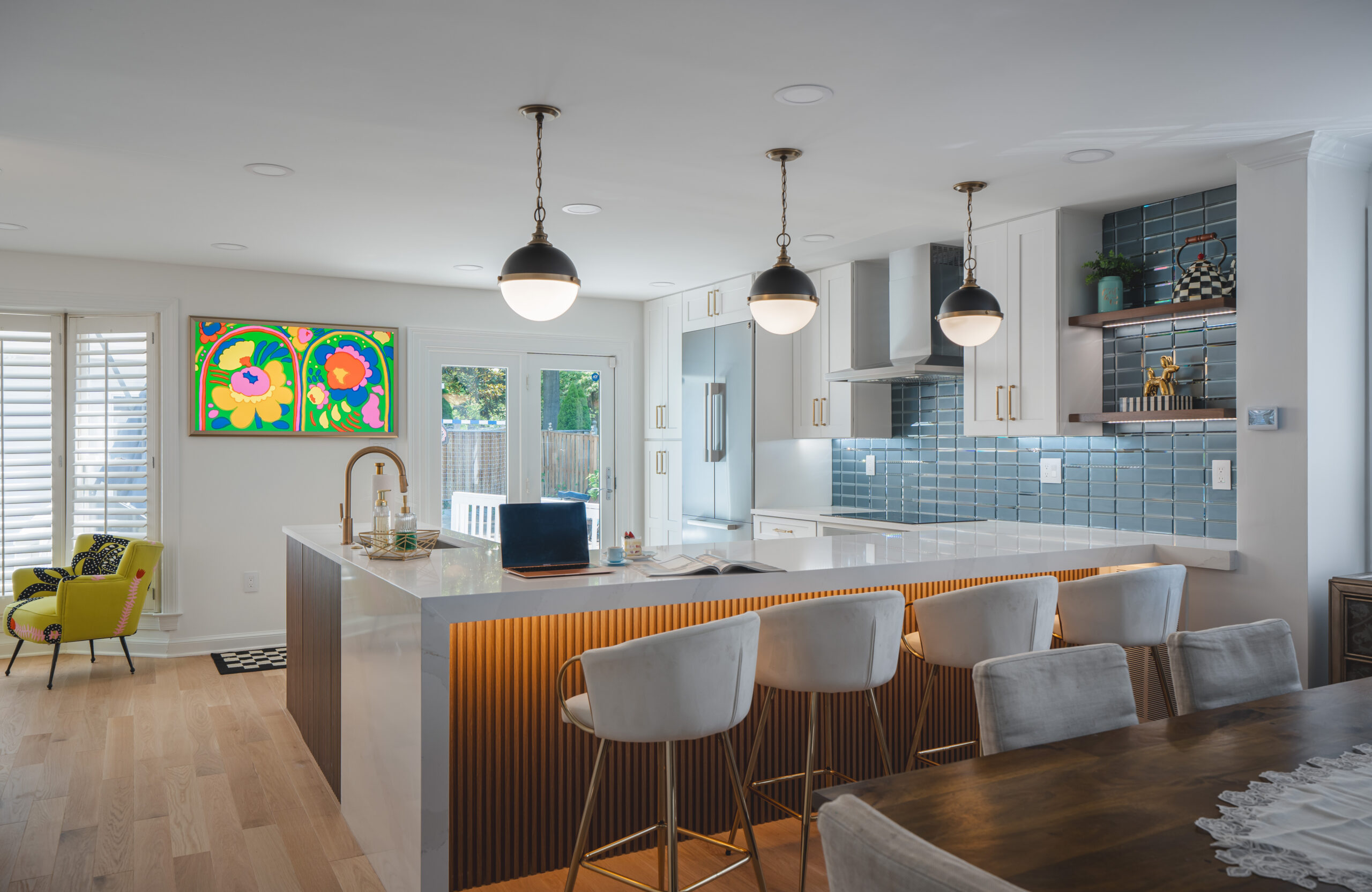 High-end kitchen renovation in Washington DC featuring a fluted wood island, gold fixtures, and blue tile backsplash.
