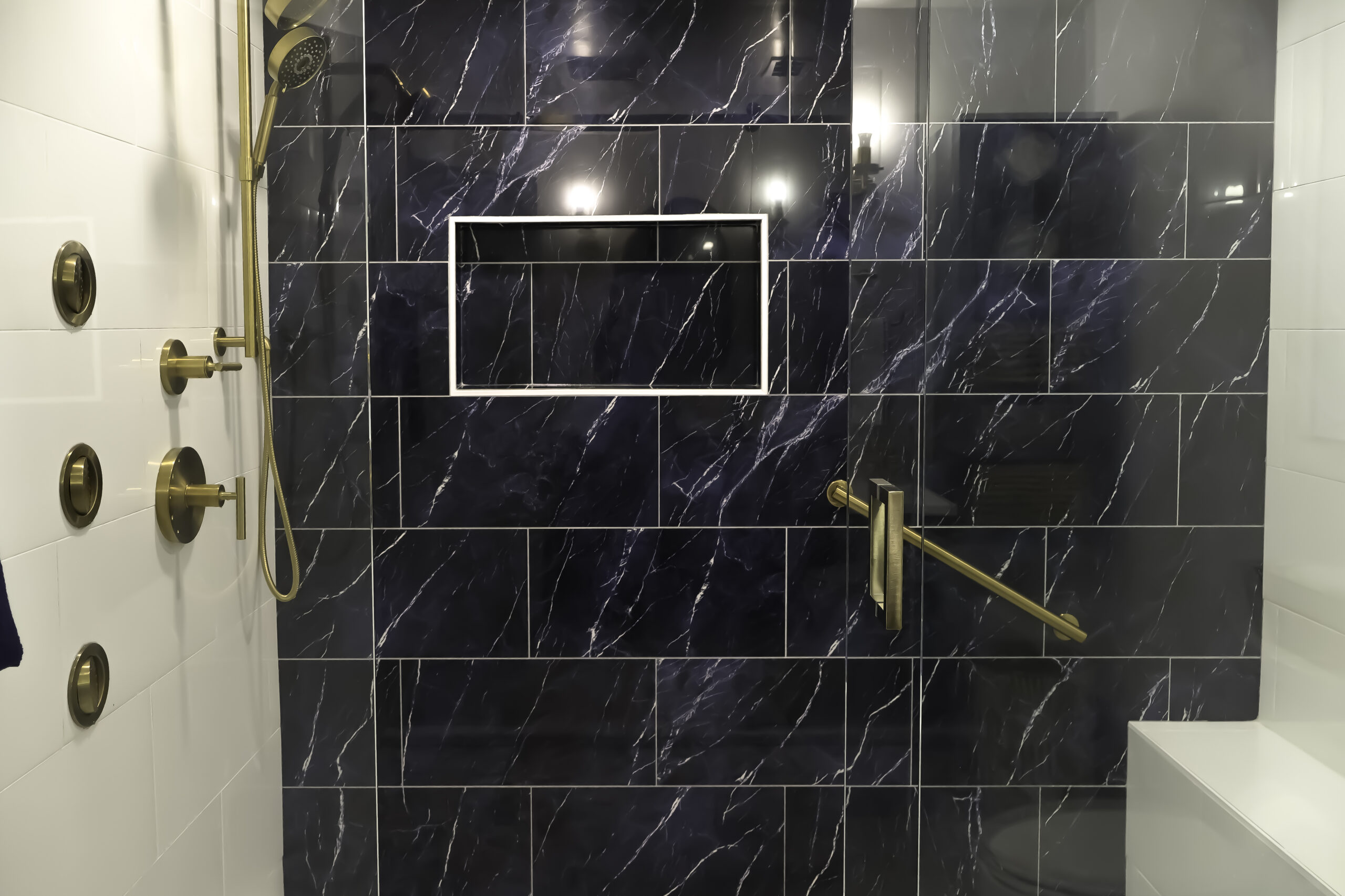Navy blue marble look porcelain tile and brushed gold fixtures for a Bathroom remodeling
