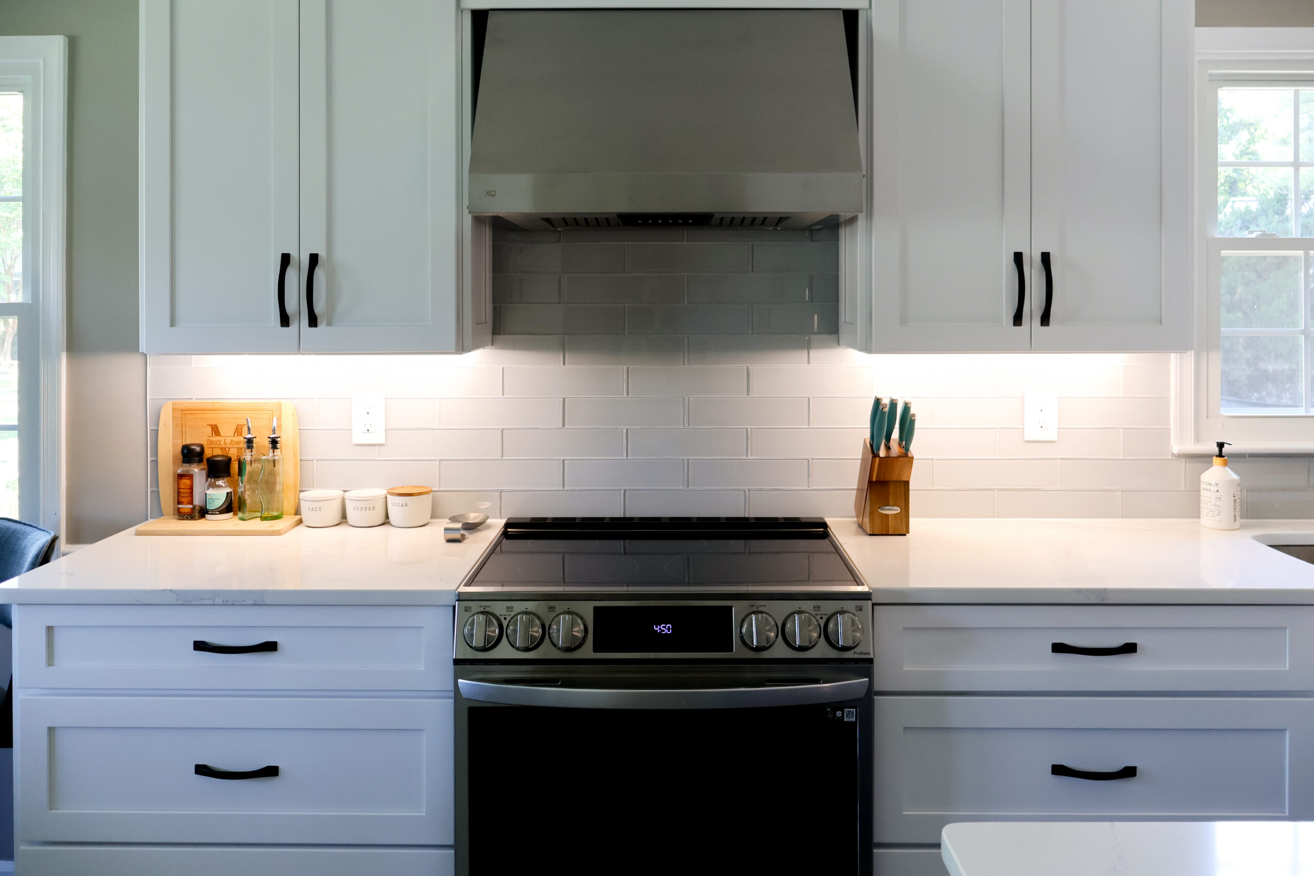 Stainless steel gas range with mitered quartz countertops on either side.