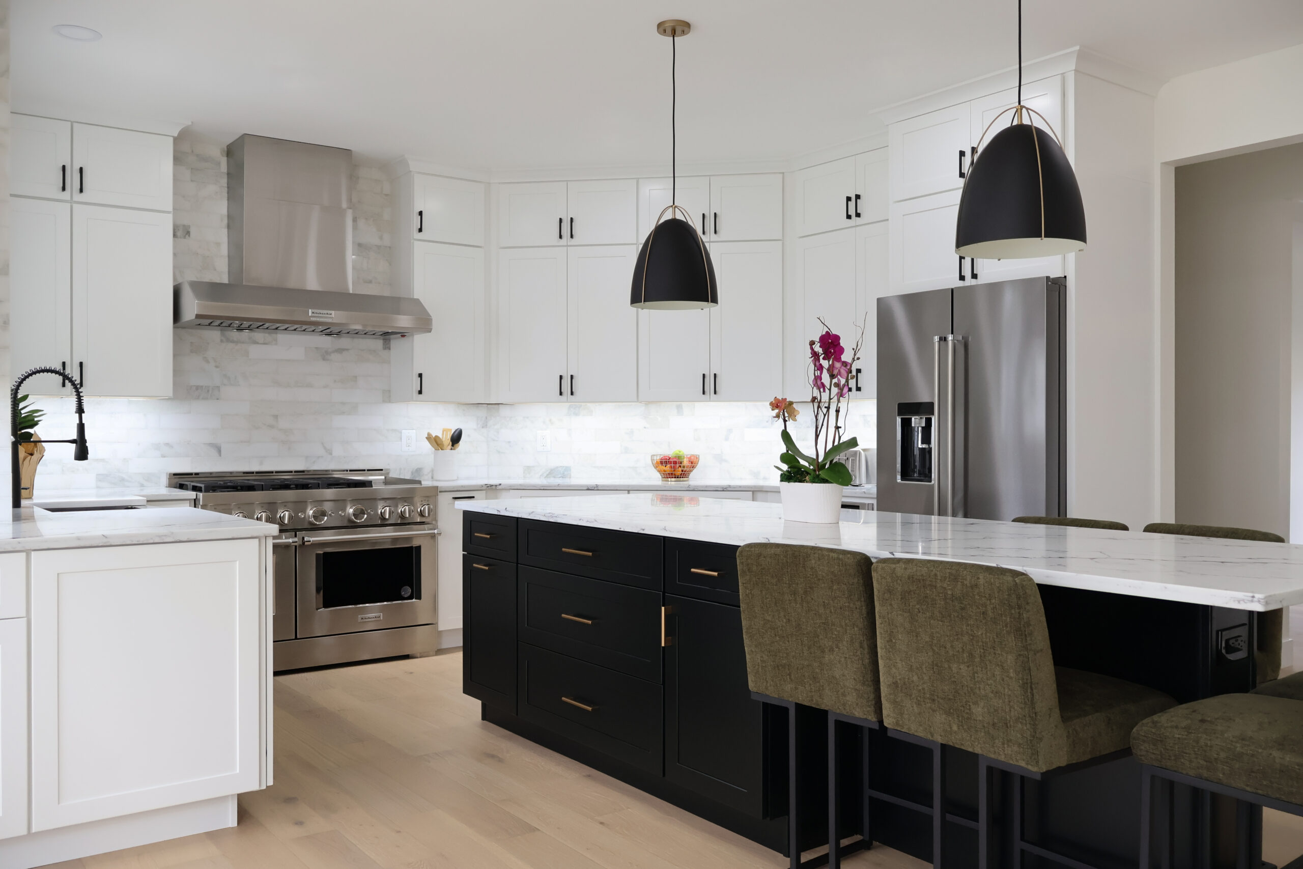 Large marble-look quartz island surface with professional stainless steel appliances nearby.