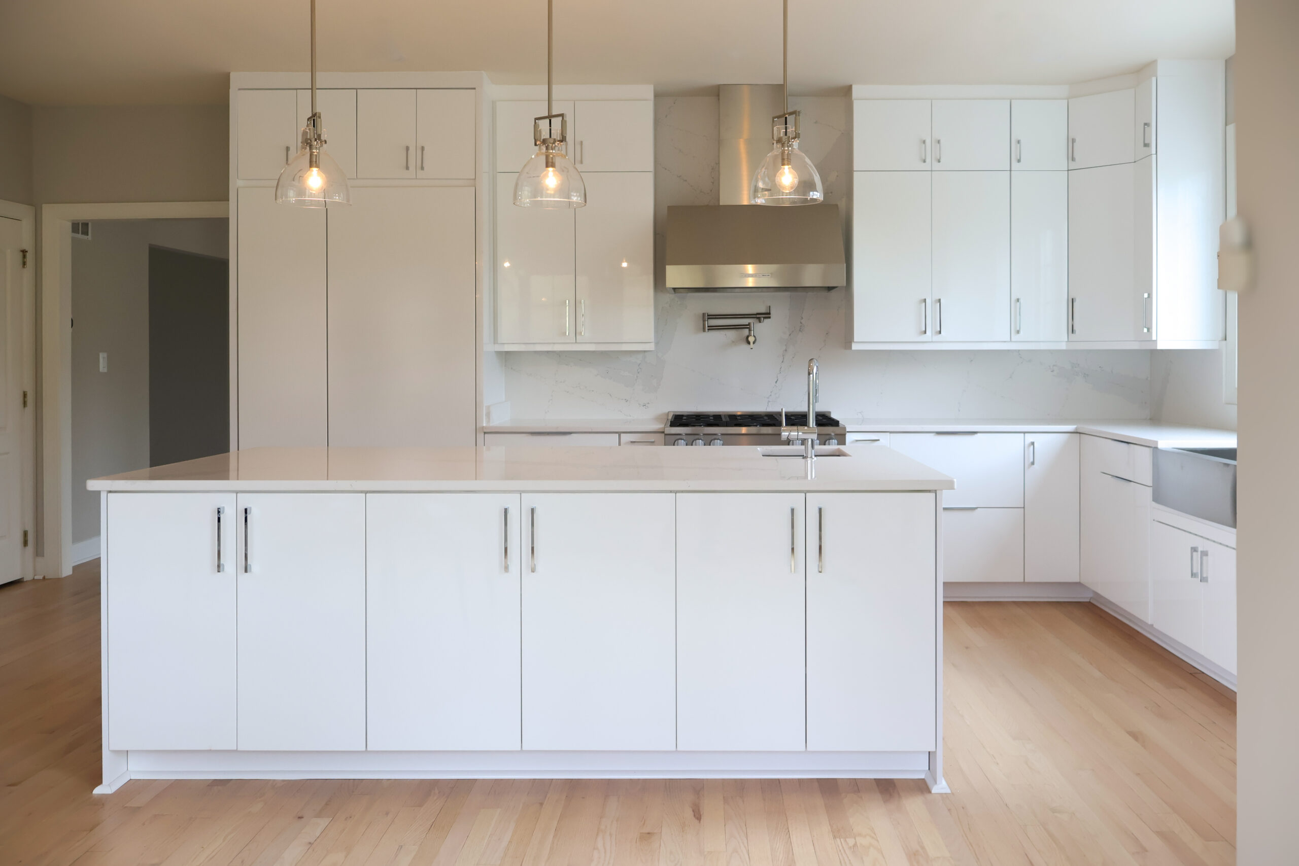 Seamless quartz slab backsplash and professional range for a Kitchen renovation.