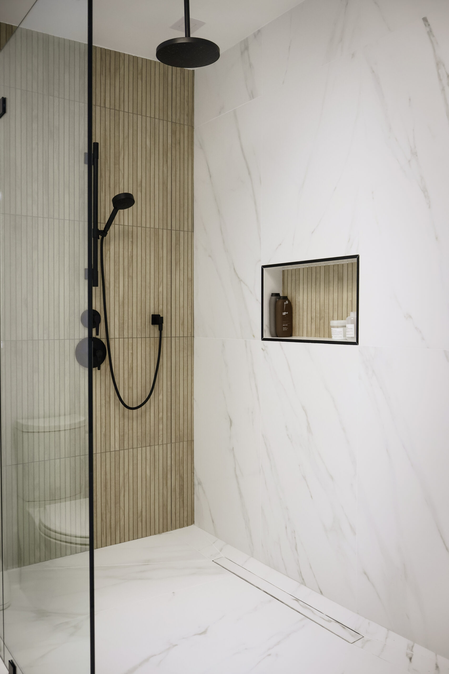 Black rainfall showerhead and integrated linear floor drain.