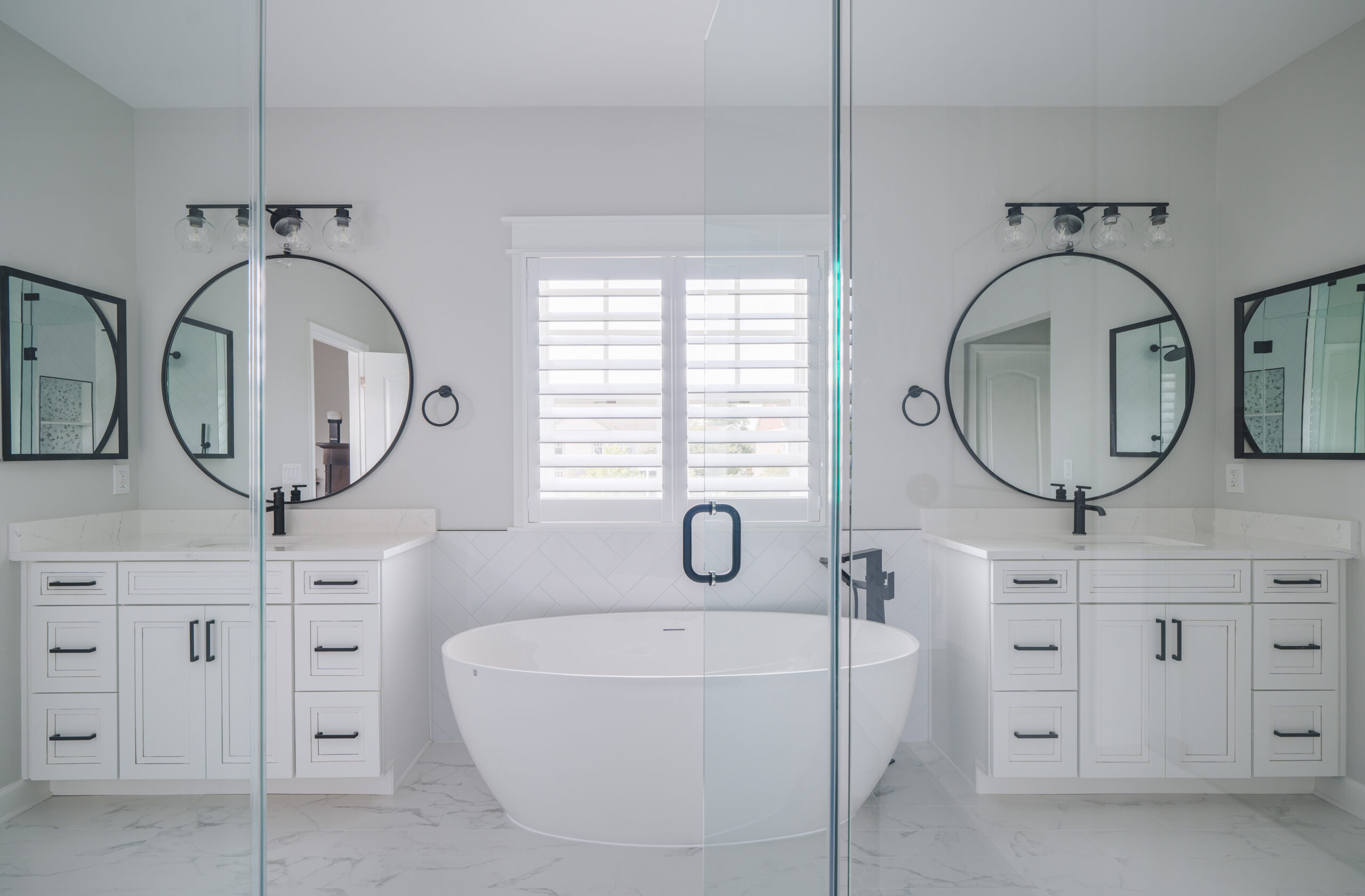 A symmetrical view showing a central white tub between two separate white vanity stations.