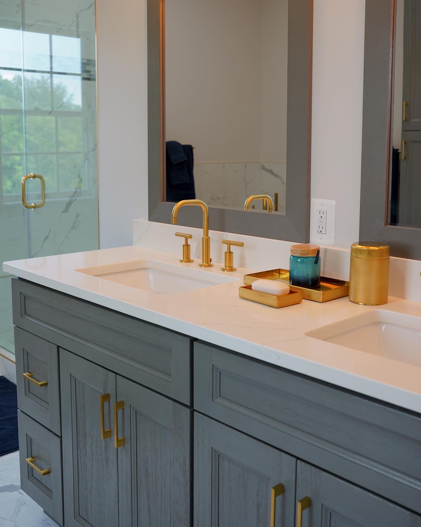 Close up of a brushed gold widespread faucet and white quartz vanity top.