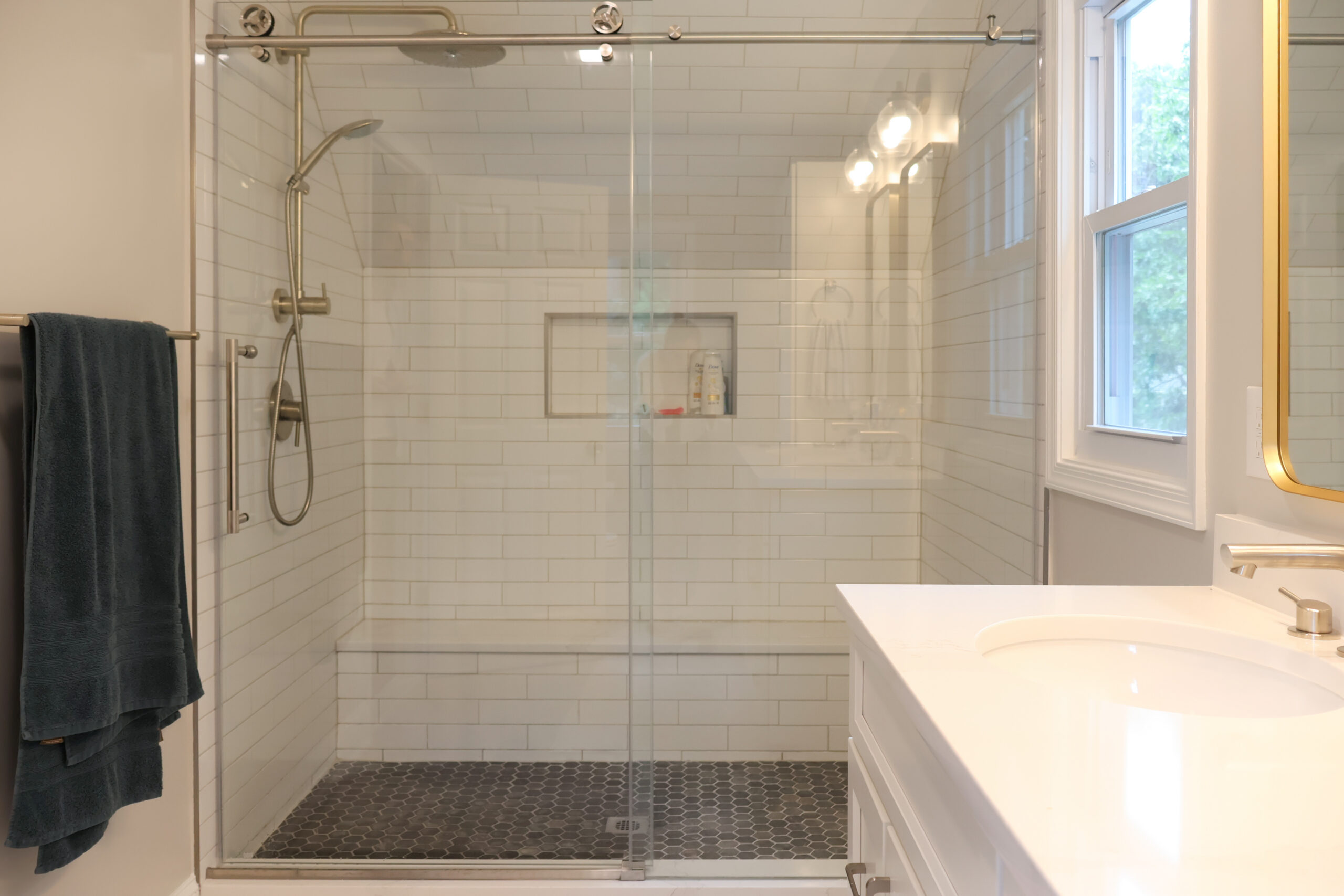 Bathroom renovation featuring a walk-in shower with subway tile and glass door.