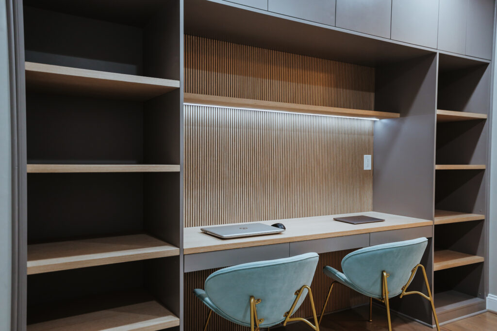 Finished basement home office with built-in storage and desk